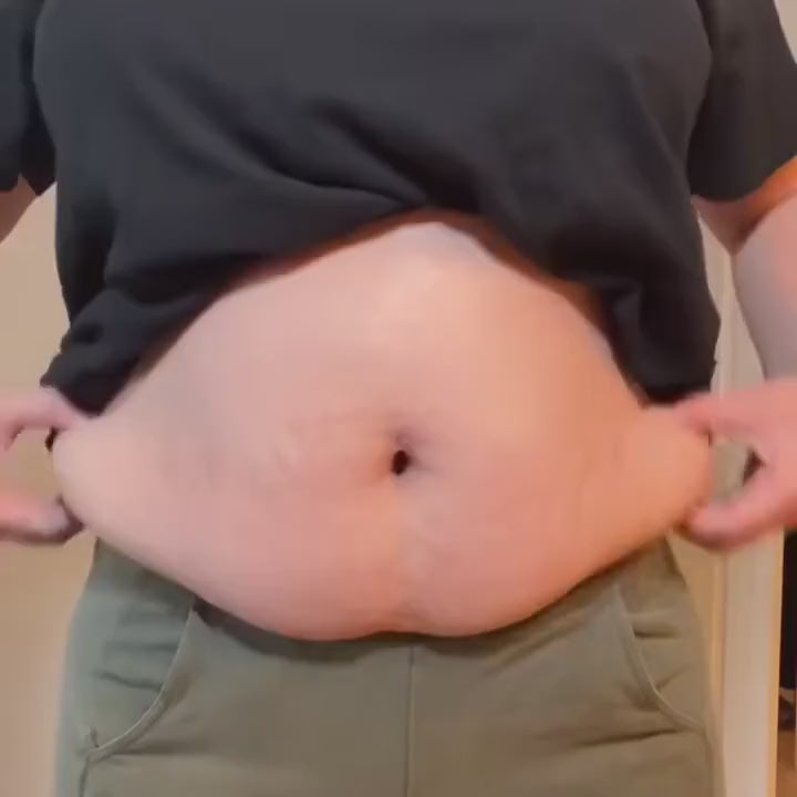 Pulling the Everyday Brief up over the belly: the wide band settles at the waist and the belly smooths flat.