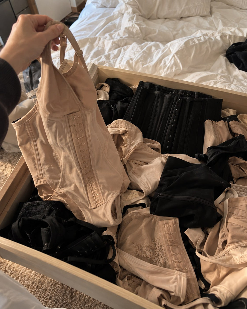 A drawer of abandoned shaping bodysuits, waist trainers and cinchers she bought and gave up on